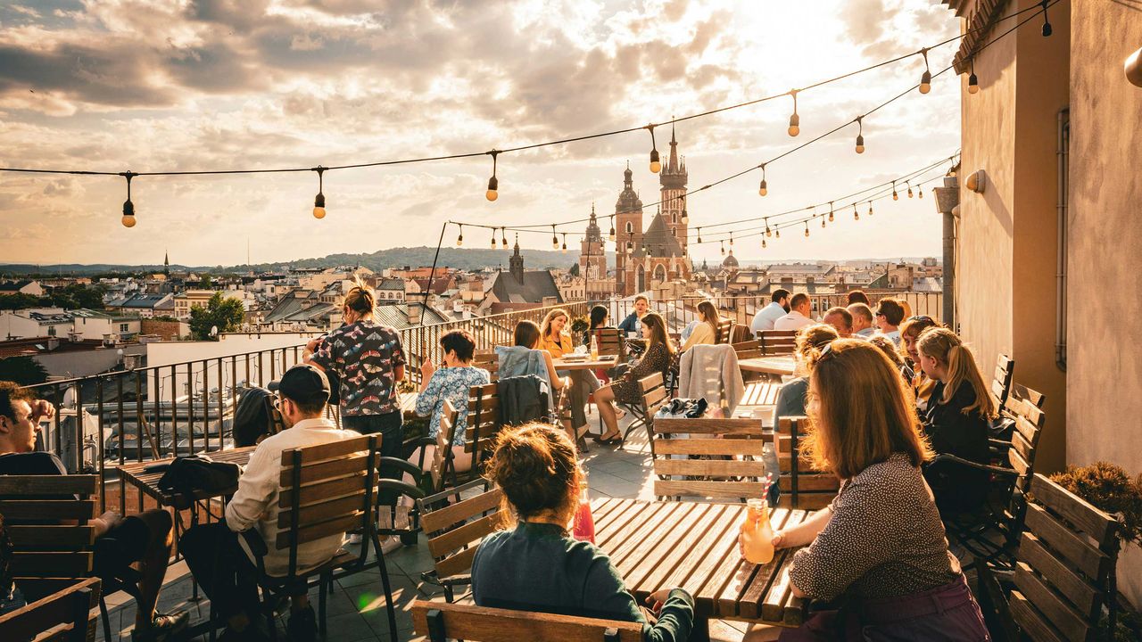Menschen sitzen auf einer Dachterrasse in Krakau
