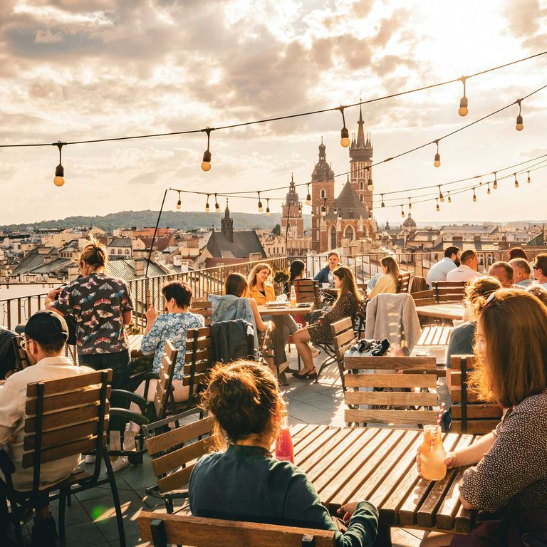 Menschen sitzen auf einer Dachterrasse in Krakau