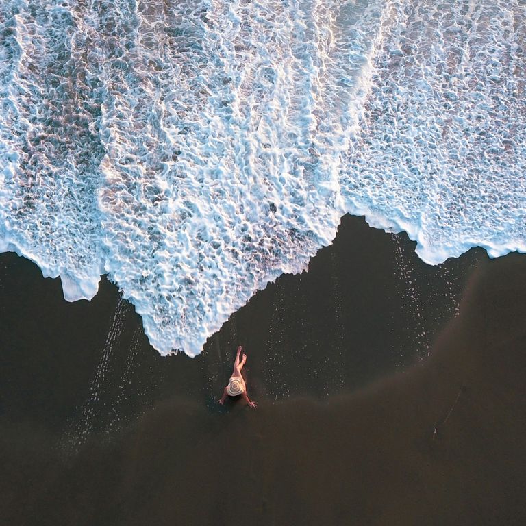 Luftaufnahme einer Frau am Lavastrand in Costa Rica